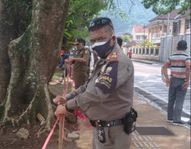 Plt. Kasi Tibumtranmas Satpol PP Sumedang Dodi Suryadi, S.Ip memasang tali pembatas di Alun-alun Sumedang, Jumat.