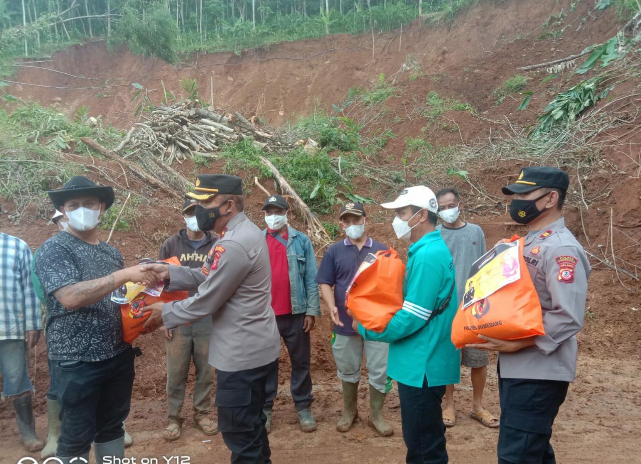 SERAHKAN: Kabag Log Polres Sumedang Kompol Idan Wahyudin didampingi Kapolsek Cibugel IPTU Ucu Abdurahman saat menyerahkan bantuan paket sembako. IMAN NURMAN