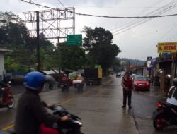 Meski Hujan, Anggota Polsek Pamulihan Polres Sumedang Ini Atur Lalu Lintas Urai Kemacetan