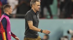 Pelatih sepak bola berjalan meninggalkan lapangan dengan ekspresi emosional