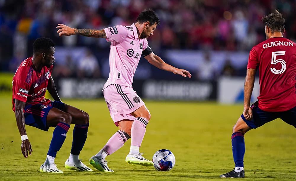 Pemain gelandang sepak bola mengontrol bola di tengah pertandingan dengan fokus tinggi