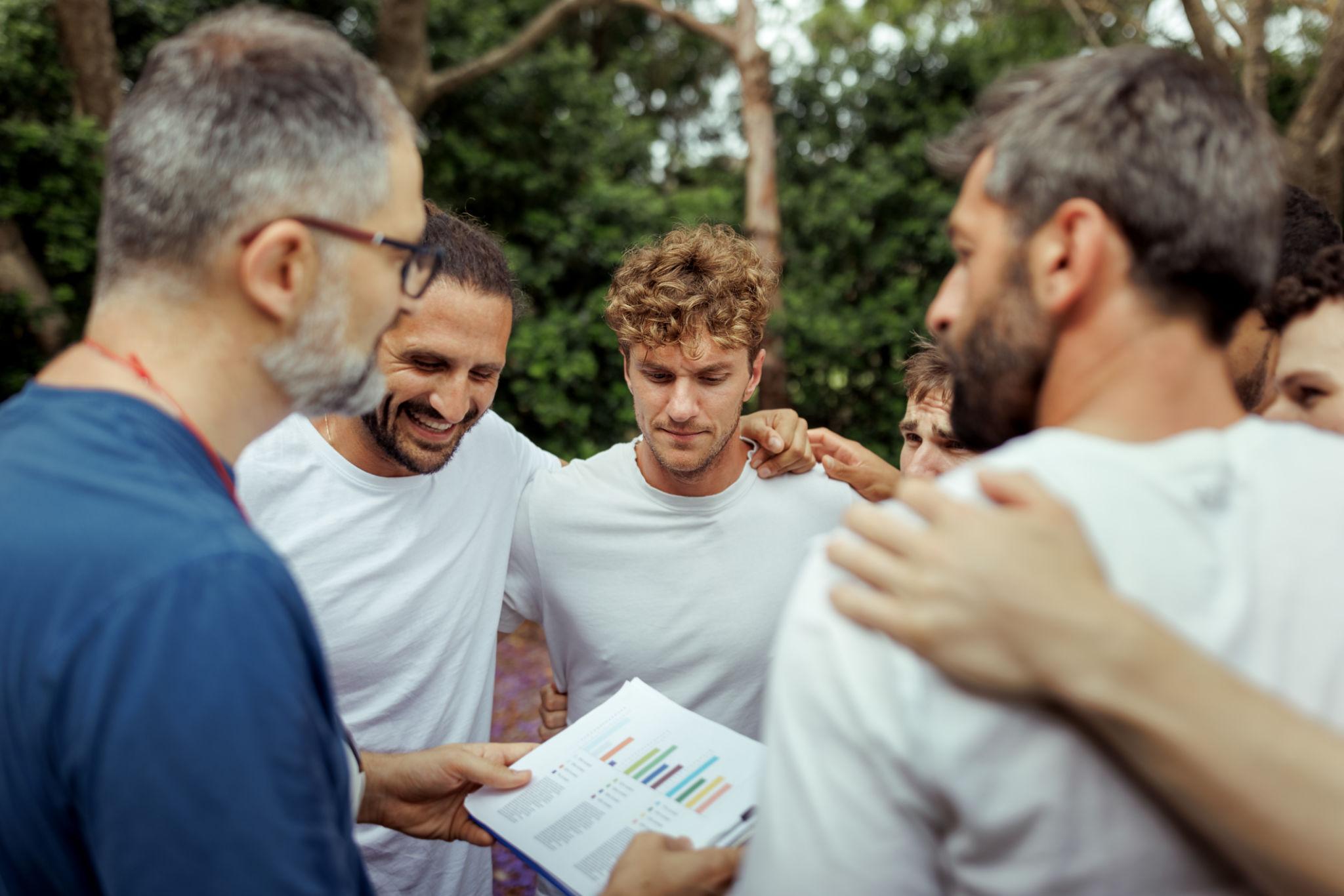 Pemain sepak bola berdiskusi strategi di lapangan saat pertandingan berlangsung