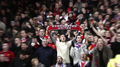 Suporter sepak bola menunjukkan reaksi emosional di stadion saat pertandingan berlangsung
