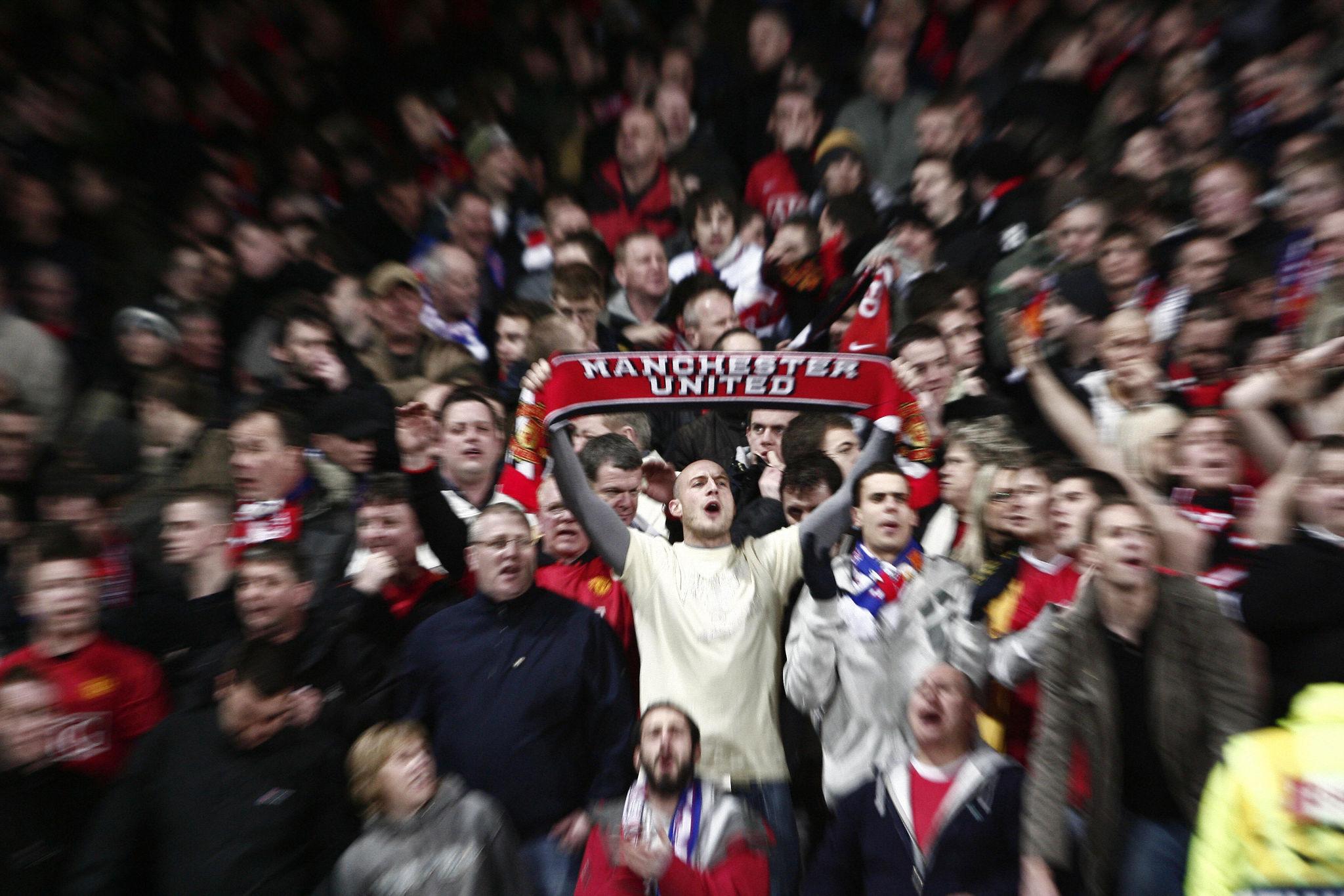 Suporter sepak bola menunjukkan reaksi emosional di stadion saat pertandingan berlangsung