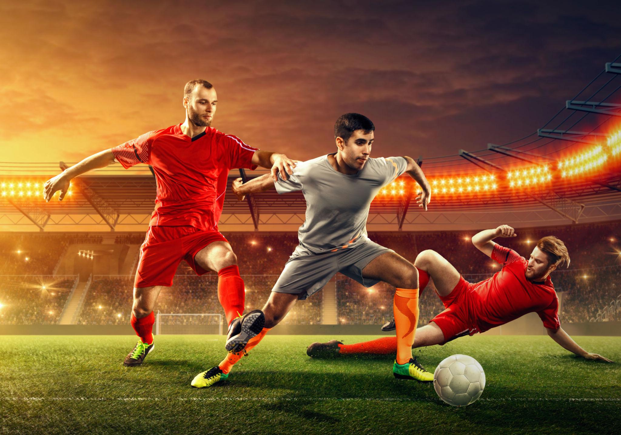 Duel sengit dua pemain dalam pertandingan sepak bola dengan suasana malam yang dramatis