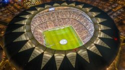 Stadion sepak bola modern dengan pencahayaan malam di kawasan Timur Tengah