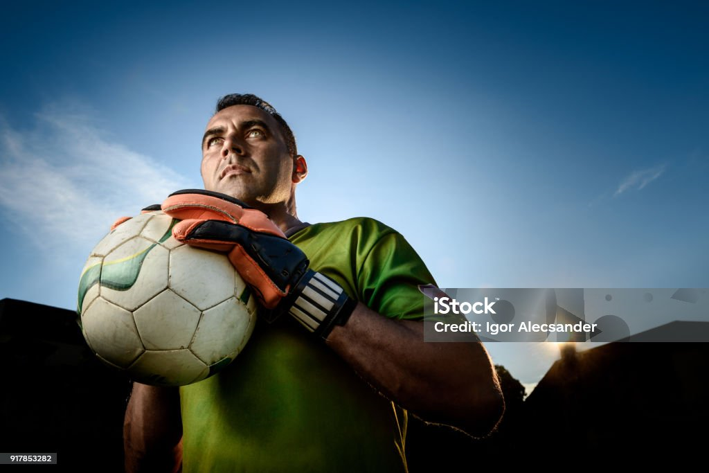kiper sepak bola melakukan penyelamatan di pertandingan malam