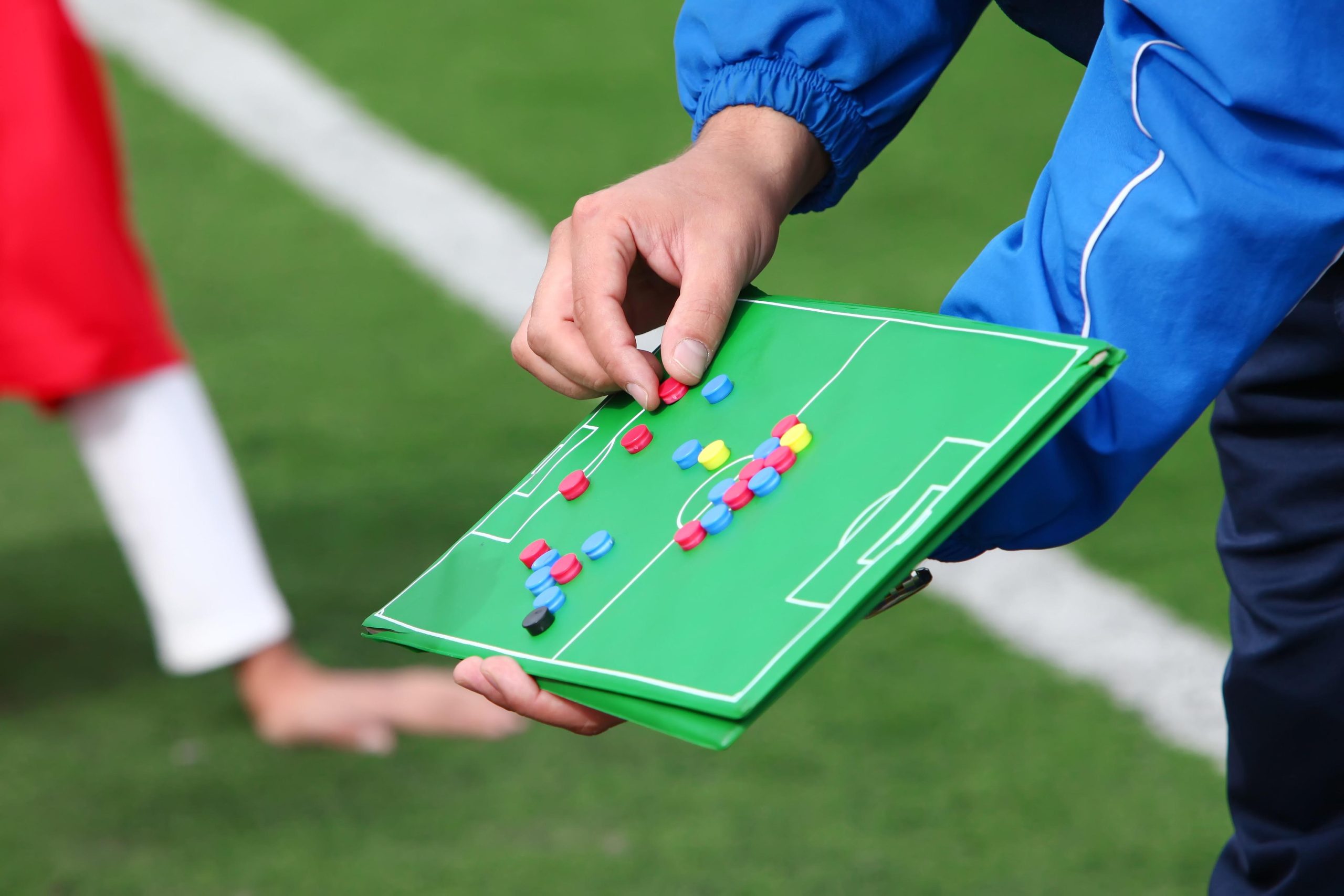 Pelatih menjelaskan strategi menggunakan papan taktik